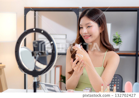 Young asian woman presenting and review cosmetic product with on social media. Young asian woman presenting and review cosmetic product with on social media. 132702427