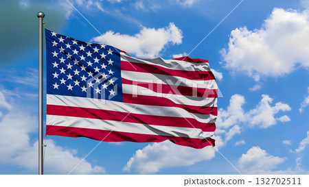 The US national flag (the Stars and Stripes) flutters against a bright blue sky and white clouds. 132702511