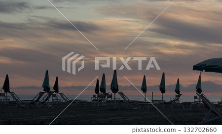 Tranquil Sunset on a Closed Beach with Umbrellas 132702660