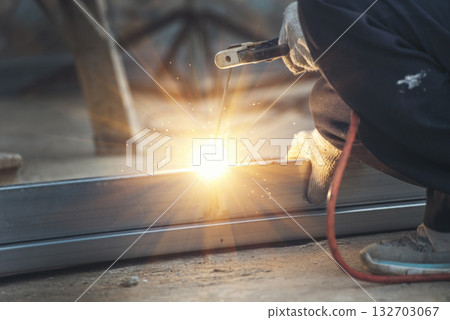 Men hands wear protective glove Hot flame metal work cutting fire iron workshop. Locksmith use Welding machine cut metal process. Construction Worker hands using Welding machinery iron metal sparking 132703067