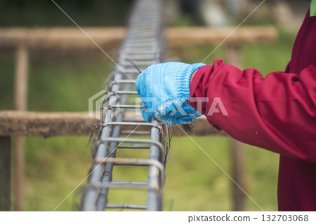 Construction Worker hands using pincer pliers iron wire. Outdoor Worker using wire bending pliers, construction work. Men hands bending cutting steel wire fences bar reinforcement of concrete work 132703068
