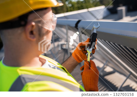 Male engineer performing solar panel maintenance Male engineer performing solar panel maintenance 132703158