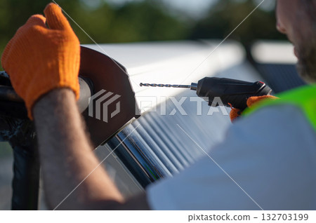 Man technician wearing gloves inspecting solar power tubes on roof Man technician wearing gloves inspecting solar power tubes on roof 132703199