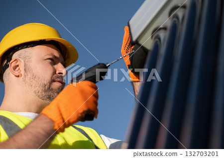 Technician wearing gloves inspecting solar power tubes on roof Technician wearing gloves inspecting solar power tubes on roof 132703201