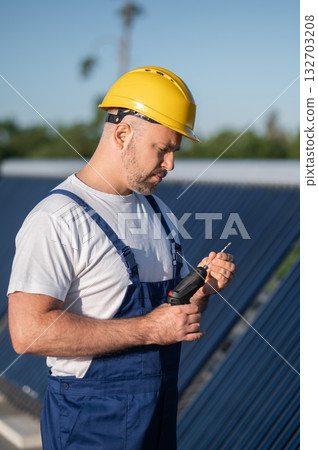 Professional engineer maintaining solar heating system on rooftop 132703208