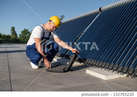 Technician using tool case examining solar power equipment Technician using tool case examining solar power equipment 132703220