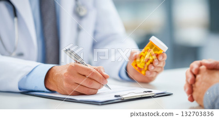 Doctor discussing medication while writing notes in a medical office 132703836