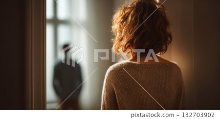 Moment of shock as woman discovers partner's affair in a dimly lit room 132703902
