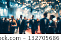 People in formal attire celebrating at a gala event with bright lights and a lively atmosphere 132705686