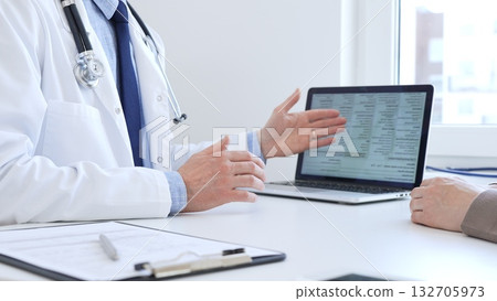 Close-up of a doctor reviewing digital test results with patient, discussing health findings on laptop screen during clinical consultation. Medicine and health care concept 132705973