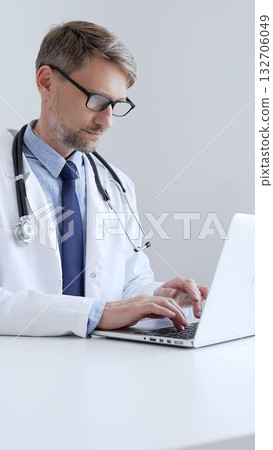 Adult doctor man is typing on a laptop, likely updating patient records or conducting research, showcasing the intersection of healthcare and technology in medical setting. Medicine concept Adult doctor man is typing on a laptop, likely updating patient records or conducting research, showcasing the intersection of healthcare and technology in medical setting. Medicine concept 132706049