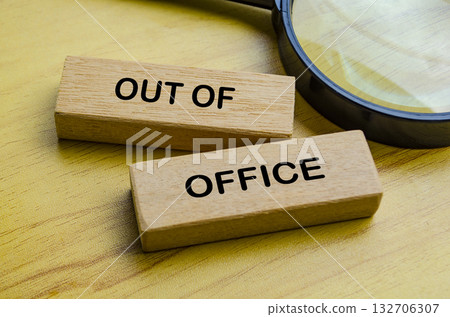 Out of office text on wooden blocks with magnifying glass background. Getaway or on a vacation concept. 132706307