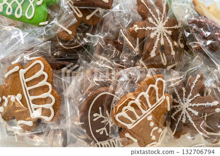 A collection of intricately decorated gingerbread cookies packaged in clear bags. The festive designs include snowflakes, mittens, and crowns piped in white icing, making them ideal for holiday gifts A collection of intricately decorated gingerbread cookies packaged in clear bags. The festive designs include snowflakes, mittens, and crowns piped in white icing, making them ideal for holiday gifts 132706794