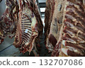 Industrial slaughterhouse scene description, Chill room with hanging beef carcasses and shadows 132707086
