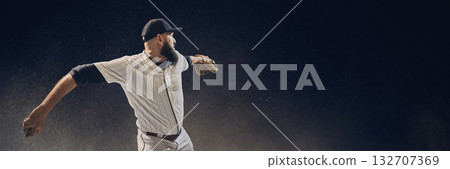 Baseball pitcher winding up before throw with dust particles floating in dramatic light. Banner Baseball pitcher winding up before throw with dust particles floating in dramatic light. Banner 132707369