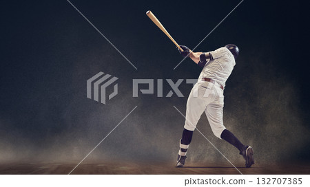 Baseball batter full follow-through swing on dusty field showing kinetic power 132707385