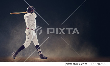 Baseball batter finishing powerful swing showing full body rotation and extension 132707389