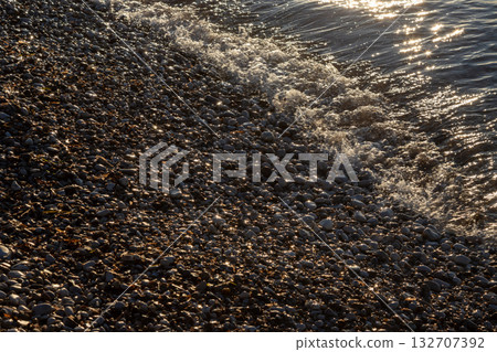 Glossy gravel and ionian sea in the sunset, Greece Glossy gravel and ionian sea in the sunset, Greece 132707392