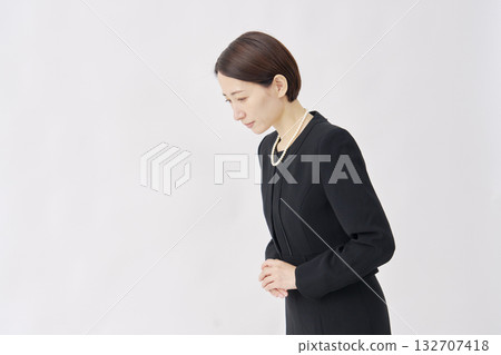 身著喪服的女子在白色背景下向左鞠躬 132707418
