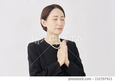 Woman in mourning clothes, hands together, white background, facing right 132707421