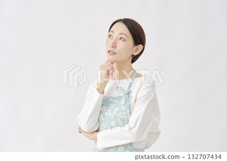 身穿圍裙的女子，白色背景，正在思考 132707434