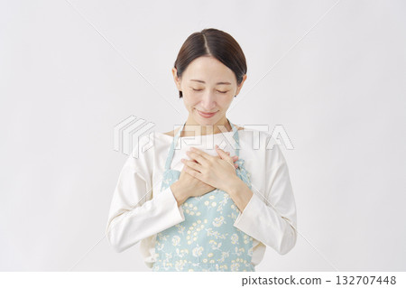 A woman wearing an apron feeling relieved, white background A woman wearing an apron feeling relieved, white background 132707448