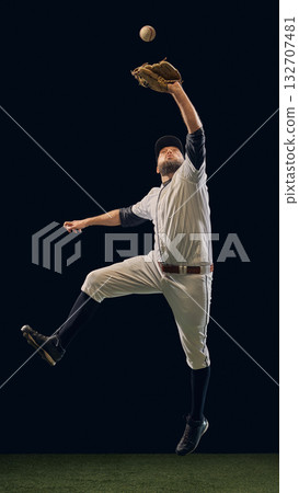 Baseball player reaching upward in jump to intercept ball with glove. Baseball player reaching upward in jump to intercept ball with glove. 132707481