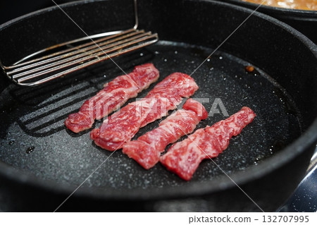 Raw Beef Strips Sizzling on a Grill Pan Raw Beef Strips Sizzling on a Grill Pan 132707995