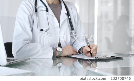 Doctor writing prescription or medical record, providing patient care and healthcare services in clinic. Medicine and health care 132708746
