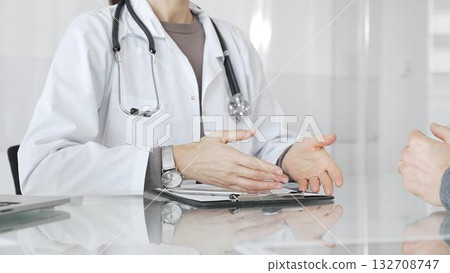 Doctor discussing medical treatment with patient during healthcare consultation, offering advice in clinic. Medicine and health care Doctor discussing medical treatment with patient during healthcare consultation, offering advice in clinic. Medicine and health care 132708747