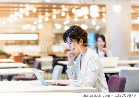 Smiling woman operating a computer in the office Smiling woman operating a computer in the office 132709679