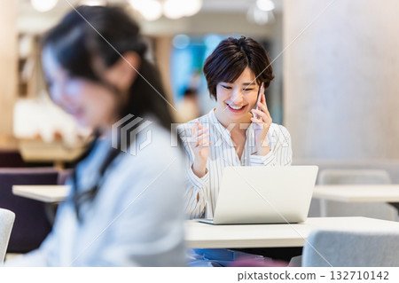 辦公室裡,一位微笑的女士正在操作電腦。 辦公室裡,一位微笑的女士正在操作電腦。 132710142