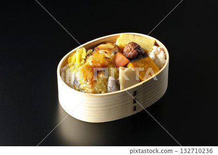 Grilled fish bento photographed against a black background 132710236