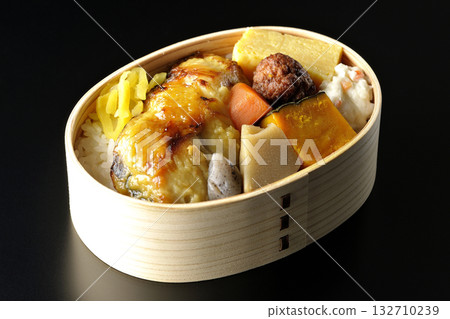 Grilled fish bento photographed against a black background 132710239