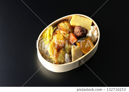 Grilled fish bento photographed against a black background Grilled fish bento photographed against a black background 132710253