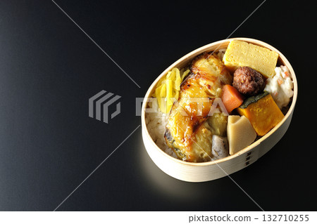 Grilled fish bento photographed against a black background 132710255