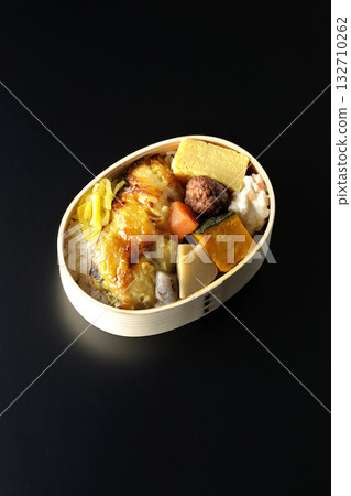 Grilled fish bento photographed against a black background Grilled fish bento photographed against a black background 132710262