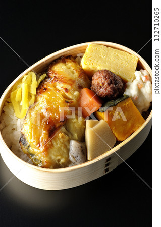 Grilled fish bento photographed against a black background Grilled fish bento photographed against a black background 132710265