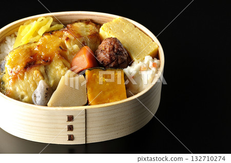 Grilled fish bento photographed against a black background 132710274