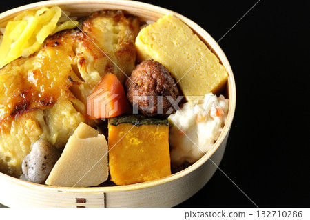Grilled fish bento photographed against a black background Grilled fish bento photographed against a black background 132710286