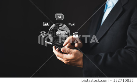 A businessman in a suit uses a smartphone with floating icons representing AI, content, creation, and digital services.Holographic elements include a globe, video, music, and idea symbols. A businessman in a suit uses a smartphone with floating icons representing AI, content, creation, and digital services.Holographic elements include a globe, video, music, and idea symbols. 132710835