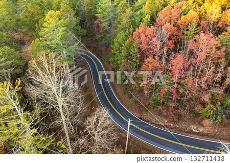 Car driving through colorful fall scenery in Appalachian region. Winding forest road surrounded by golden leaves and cool mountain air 132711438