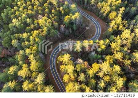 Car driving through colorful fall scenery in Appalachian region. Winding forest road surrounded by golden leaves and cool mountain air 132711439