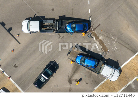 Car crash site with tow truck loading destroyed vehicle on American street. Emergency services personnel responding to accident in Florida, USA Car crash site with tow truck loading destroyed vehicle on American street. Emergency services personnel responding to accident in Florida, USA 132711440