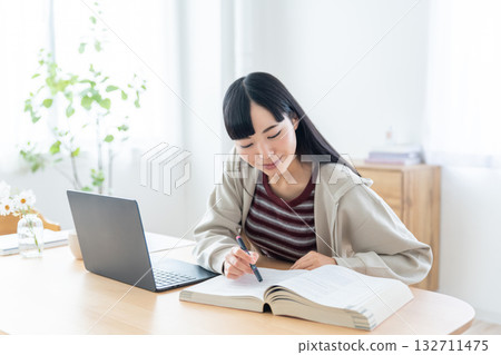 Young woman studying at home Young woman studying at home 132711475