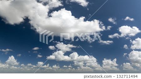 Bright landscape of blue sky with flying white clouds. Colorful summer skyscape Bright landscape of blue sky with flying white clouds. Colorful summer skyscape 132711494