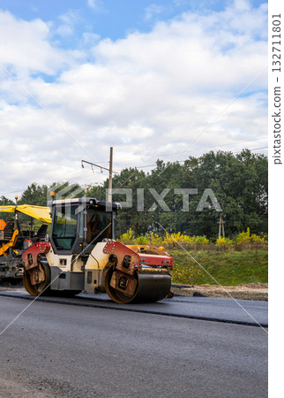 Heavy road roller machine working on fresh asphalt during road construction Heavy road roller machine working on fresh asphalt during road construction 132711801