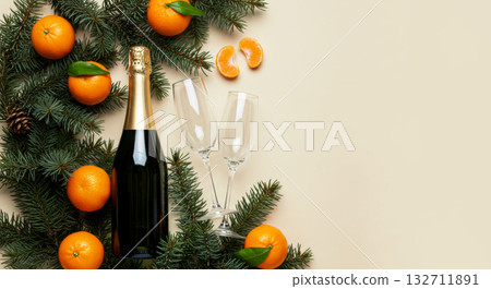 New Year's composition with a champagne bottle, empty glasses, fir branches, and fresh mandarin oranges. 132711891