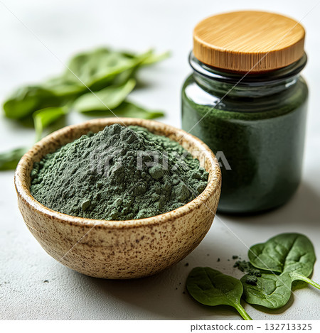 Jar of green powder next to a bowl of green powder Jar of green powder next to a bowl of green powder 132713325