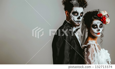 Couple in Halloween costumes with skull makeup and elegant attire, celebrating festive occasion 132713374